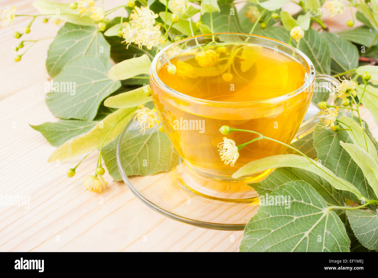 linden flowers and cup of healthy tea, herbal medicine Stock Photo