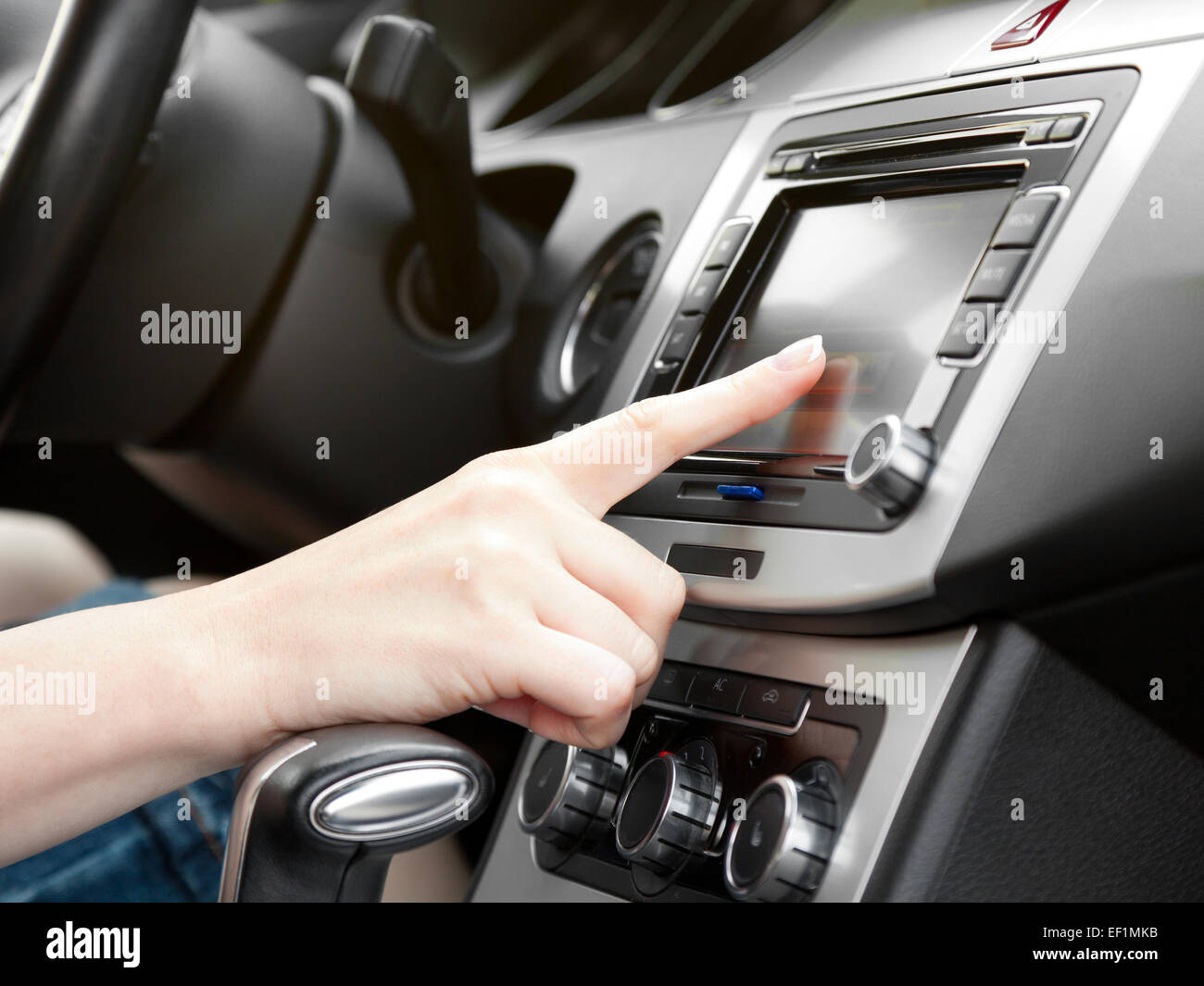 finger on dashboard with gps panel and tv/dvd/audio system Stock Photo