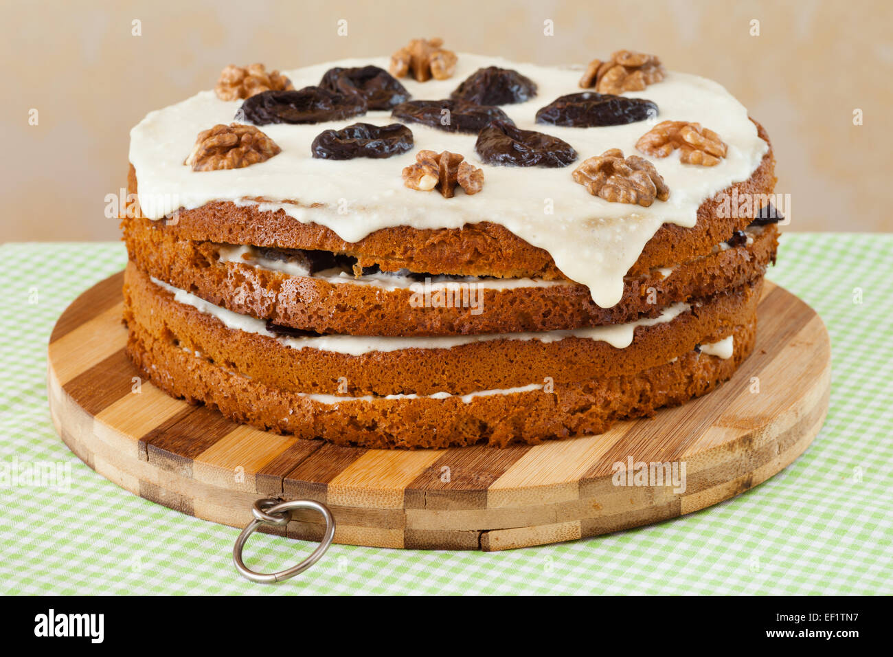 honey cake with plum and walnut on kitchen table Stock Photo