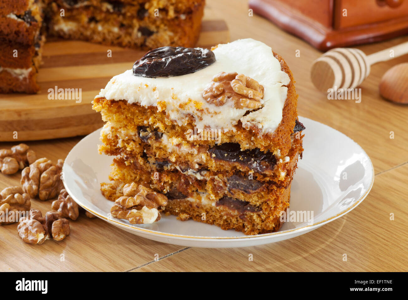 piece of honey cake with plum and walnut on kitchen table Stock Photo