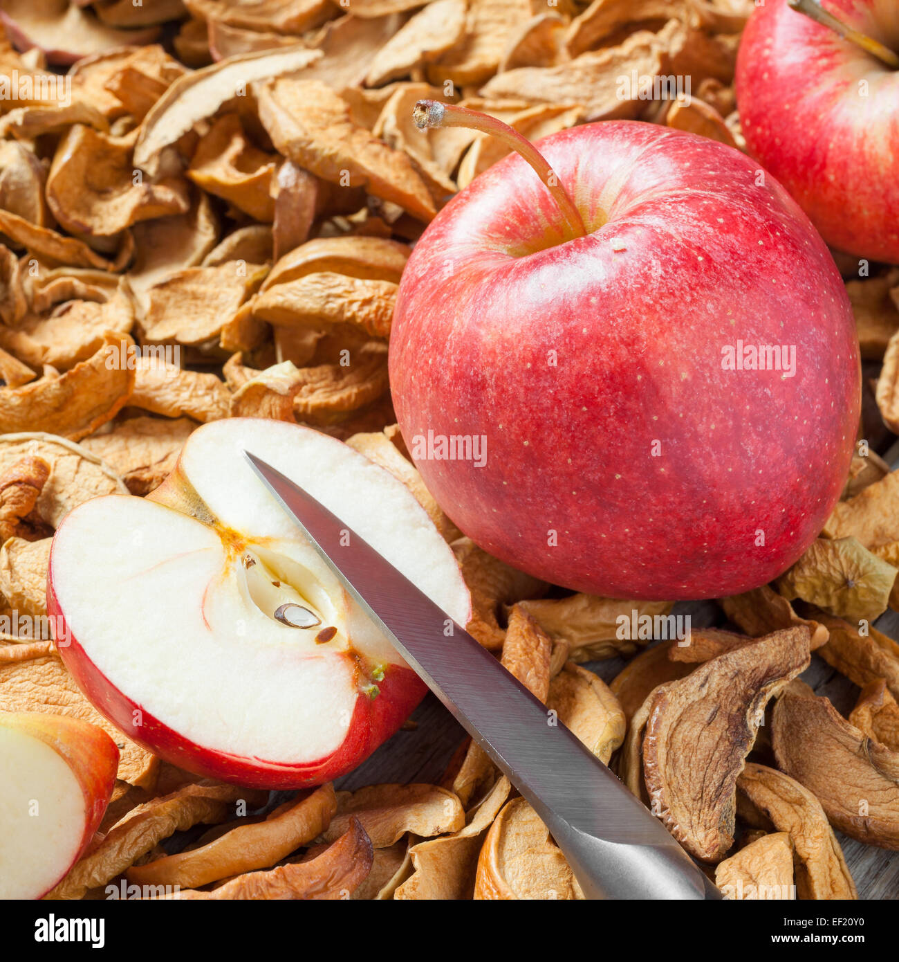 dried apple slices, knife and red fresh red apple fruit close up Stock Photo