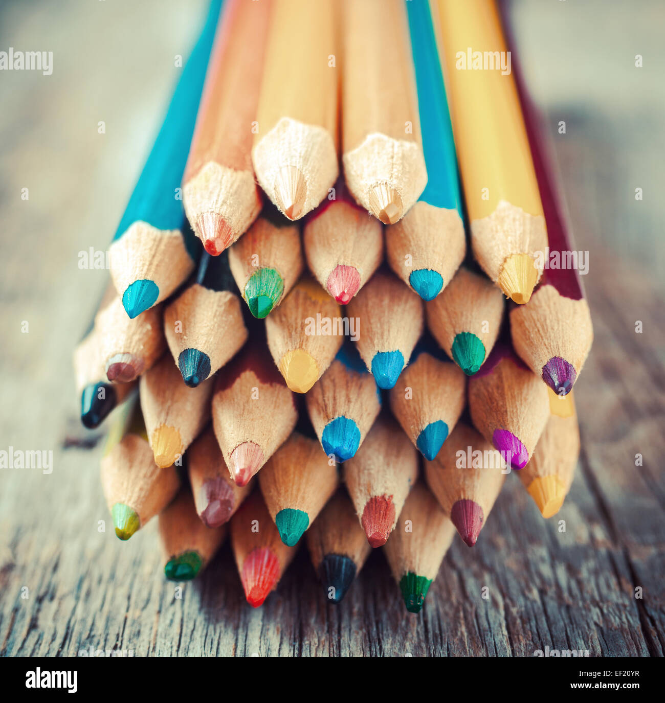 Colored drawing pencils closeup on old desk. Vintage stylized image. Stock Photo
