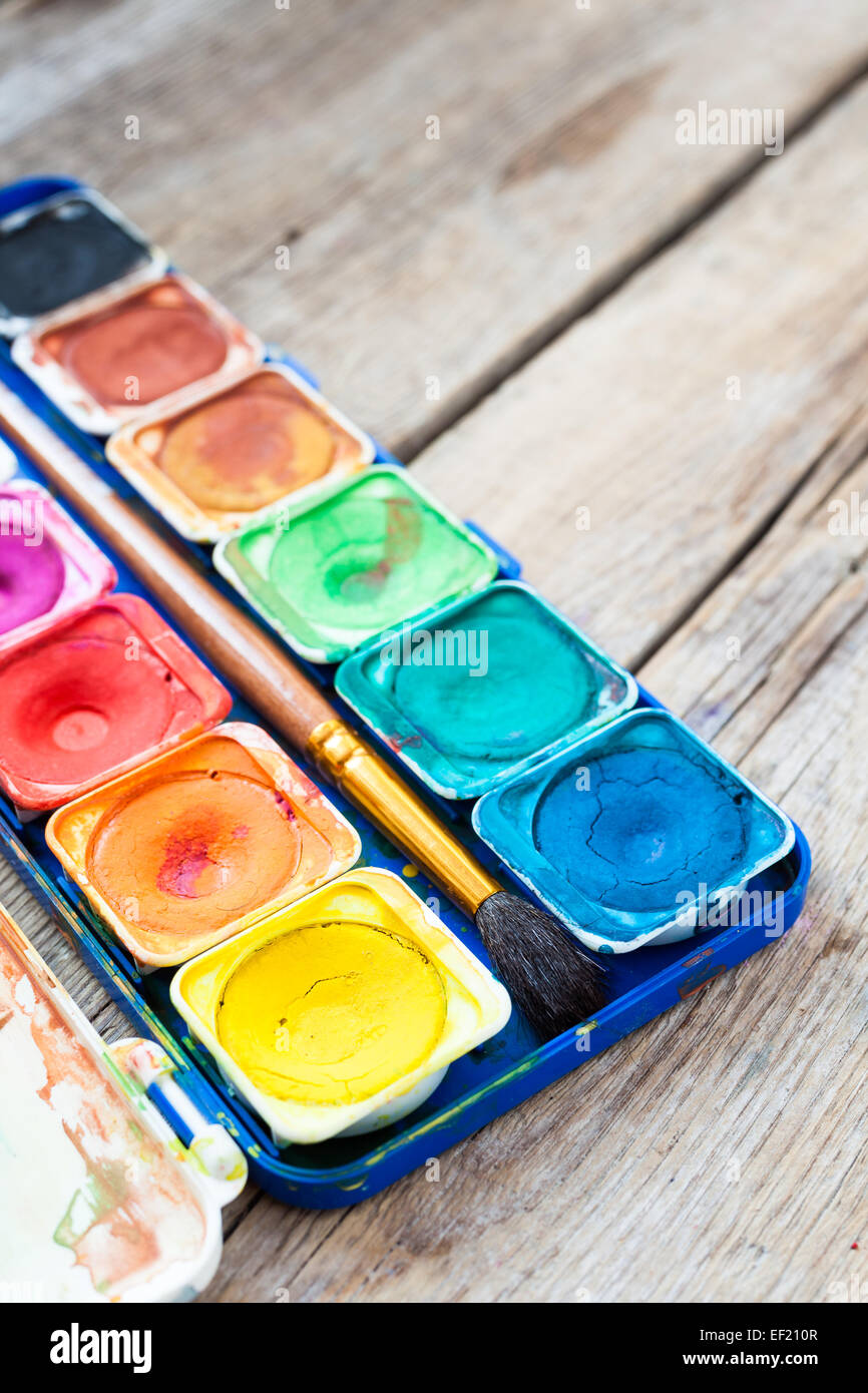 Set of watercolor paints on vintage wooden background. Stock Photo