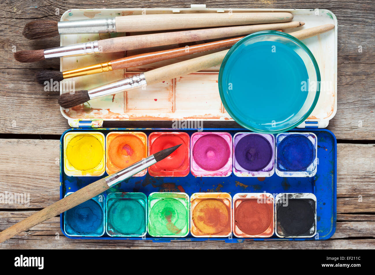 https://c8.alamy.com/comp/EF211C/set-of-watercolor-paints-art-brushes-and-glass-of-water-on-old-wooden-EF211C.jpg