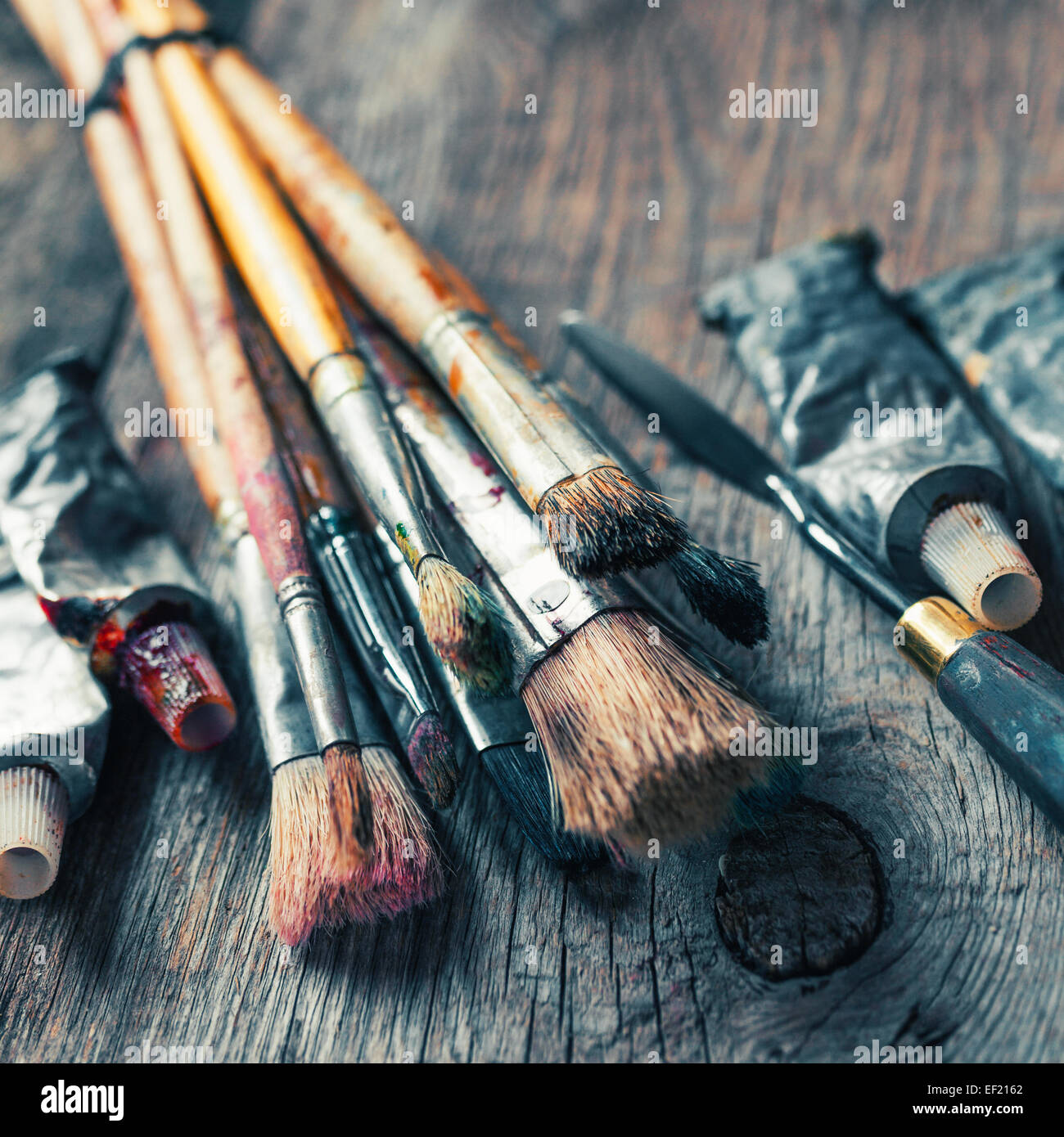 Artist paint brushes and oil paint tubes on wooden palette. Texture mixed  oil paints in different colors. Instruments and tools for creative leisure  Stock Photo - Alamy