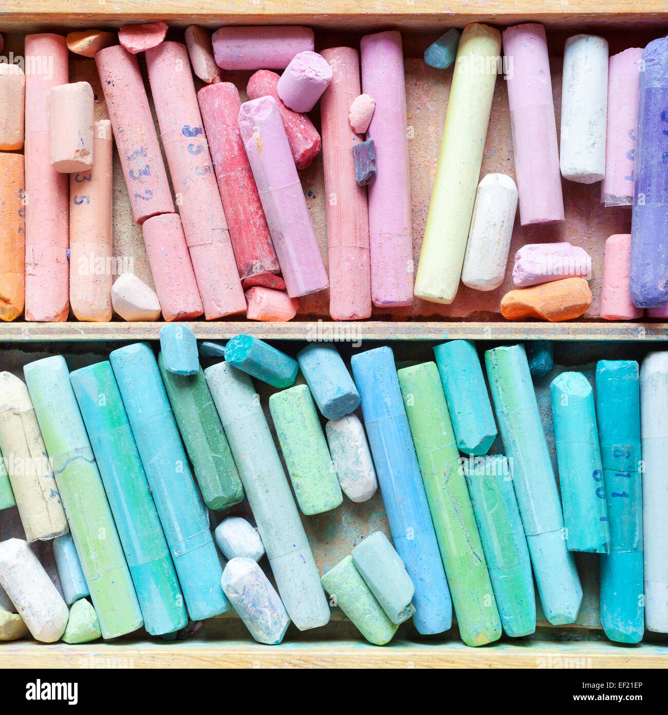 Professional pastel crayons in wooden artist box closeup, top view