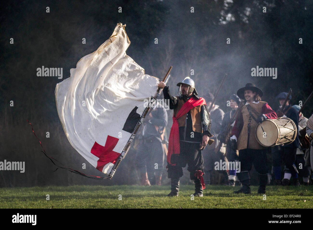 Nantwich, Cheshire, UK. 24th Jan, 2015.  Battle Flags fly & Standard Bearer at Holly Holy Day & Siege of Nantwich re-enactment.  For over 40 years the faithful troops of The Sealed Knot have gathered in the historic town for a spectacular re-enactment of the bloody battle that took place almost 400 years ago and marked the end of the long and painful siege of the town.  Roundheads, cavaliers, and other historic entertainers converged upon the town centre to re-enact the Battle. The siege in January 1644 was one of the key conflicts of the English Civil War. Stock Photo