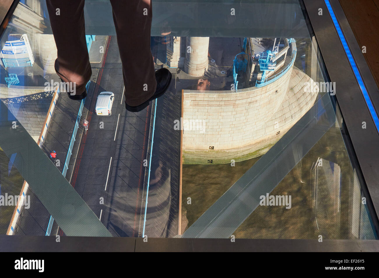 Tourist standing on the high level glass walkway of Tower Bridge 42 metres above the road and river Thames London England Europe Stock Photo