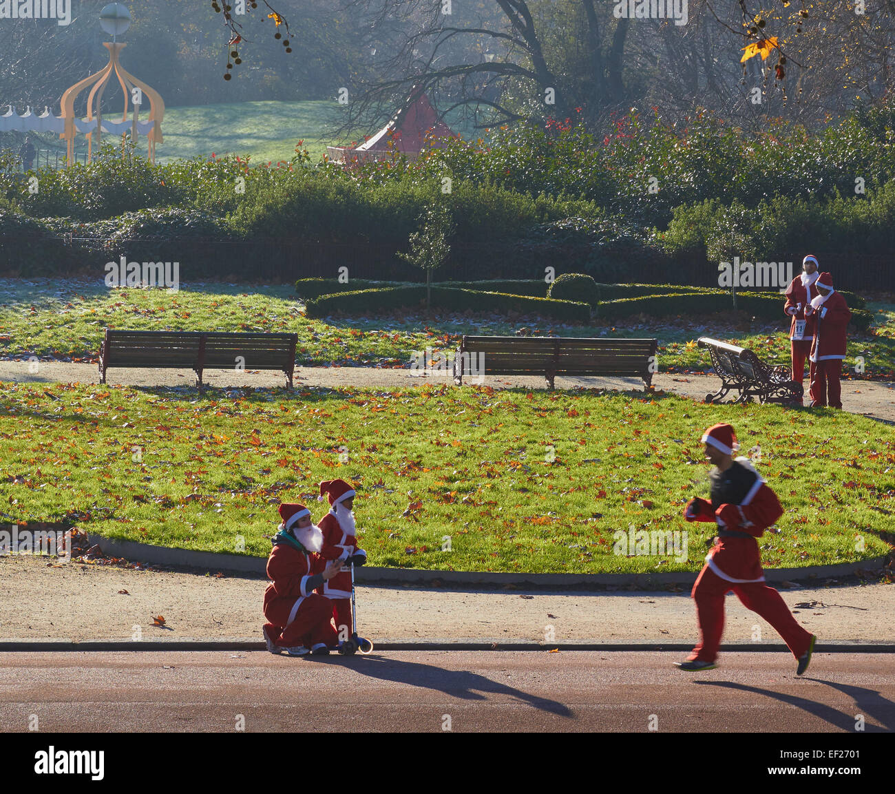 Participants in the annual santa run on a sunny winters morning in Battersea Park, London, England, Europe. Stock Photo