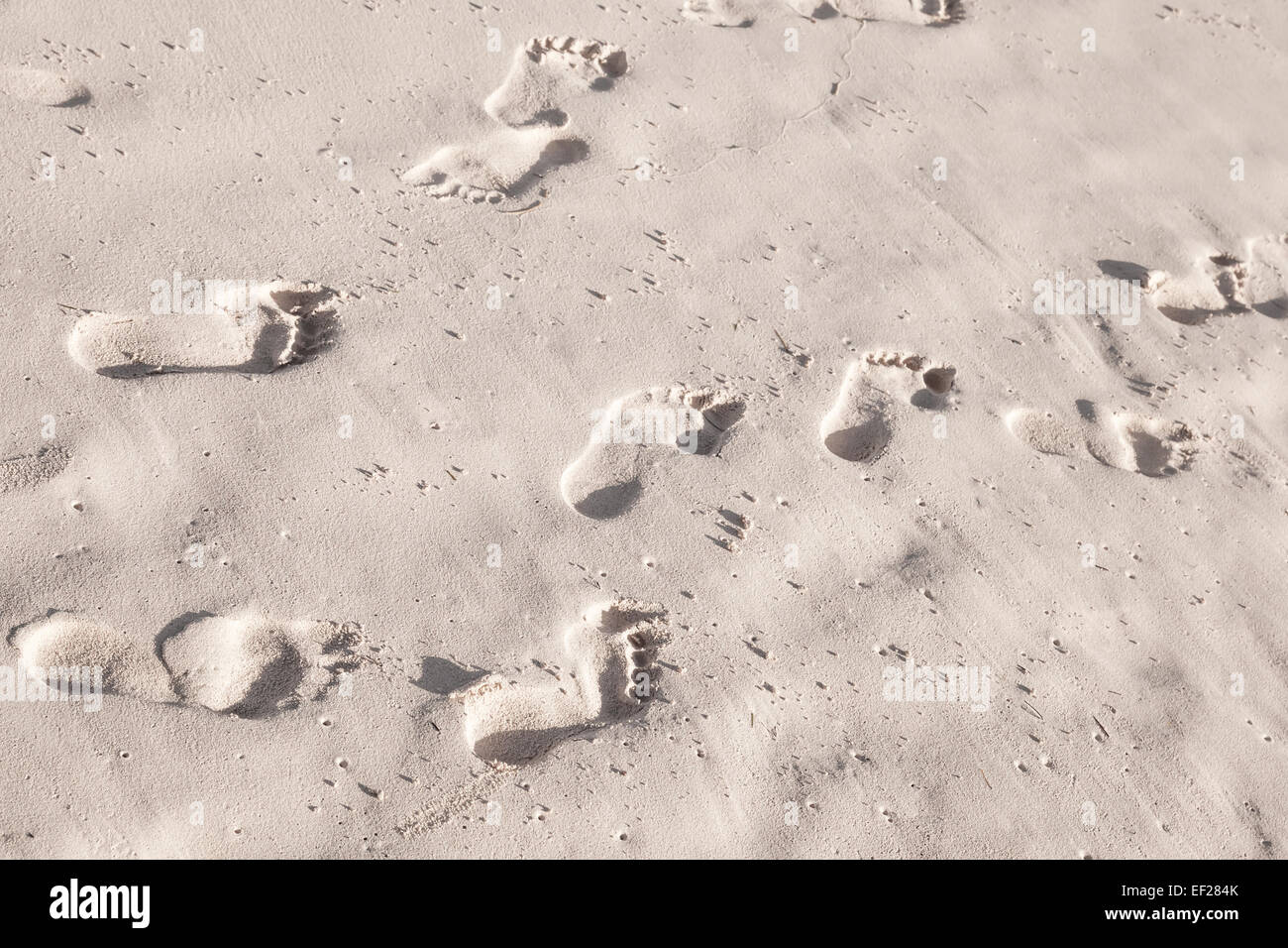 Footprints in white coastal sand on the ocean beach Stock Photo