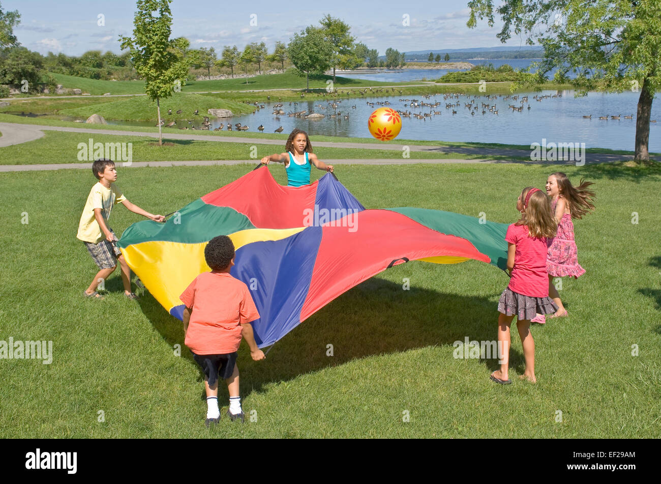 Children playing with a parachute Stock Photo - Alamy