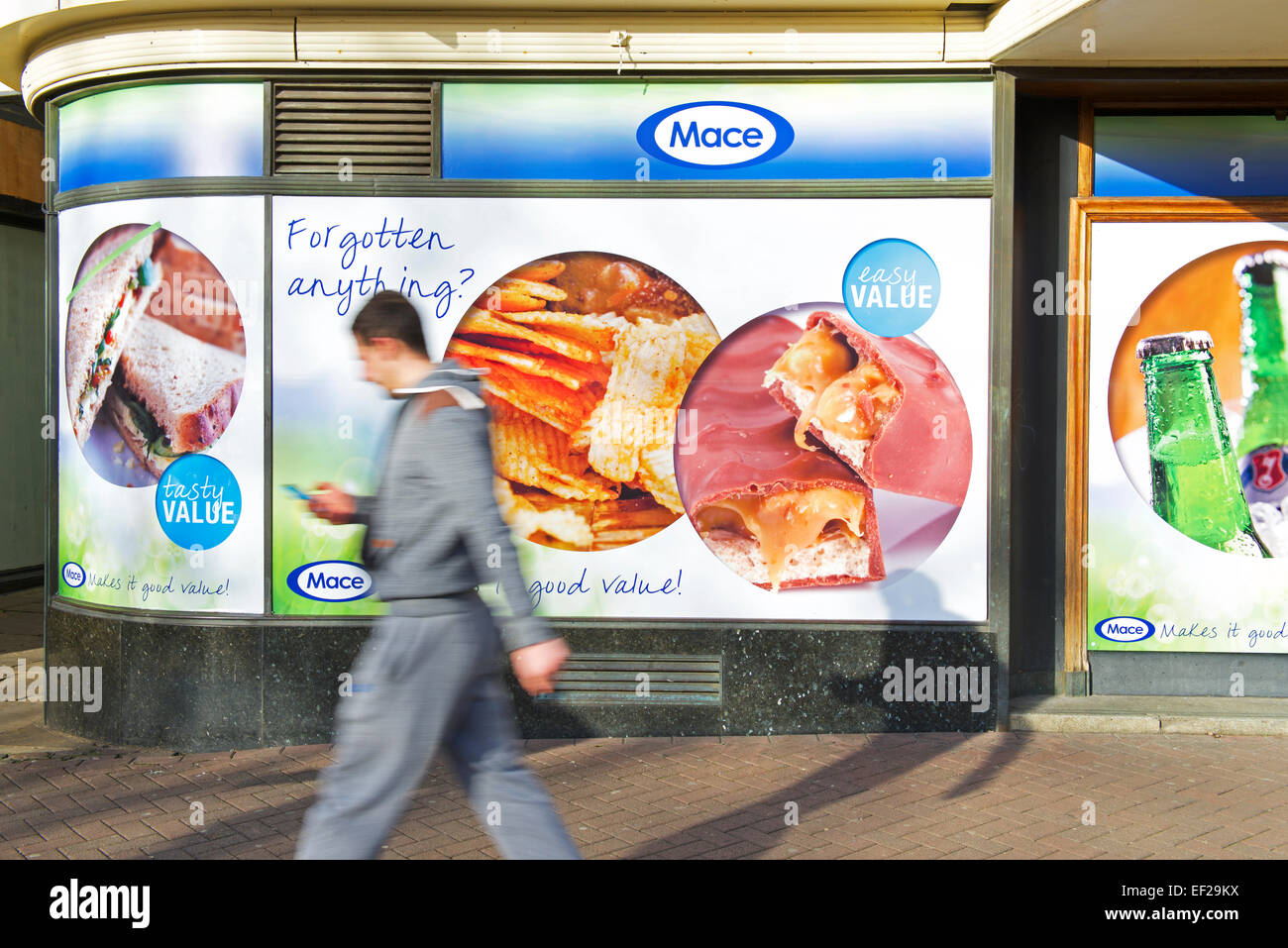 Man walking past Mace convenience store, England UK Stock Photo