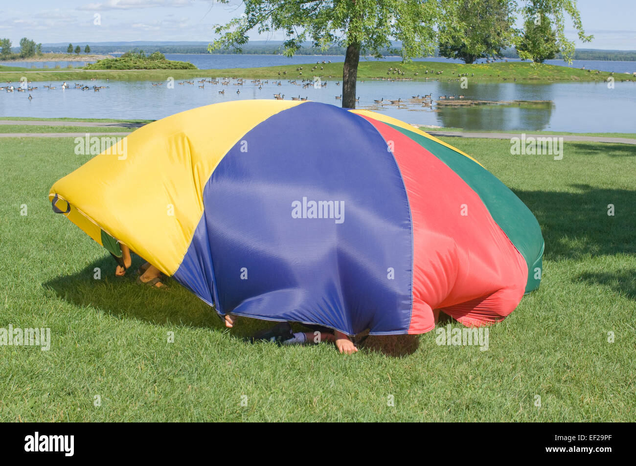 Children playing with a parachute Stock Photo - Alamy