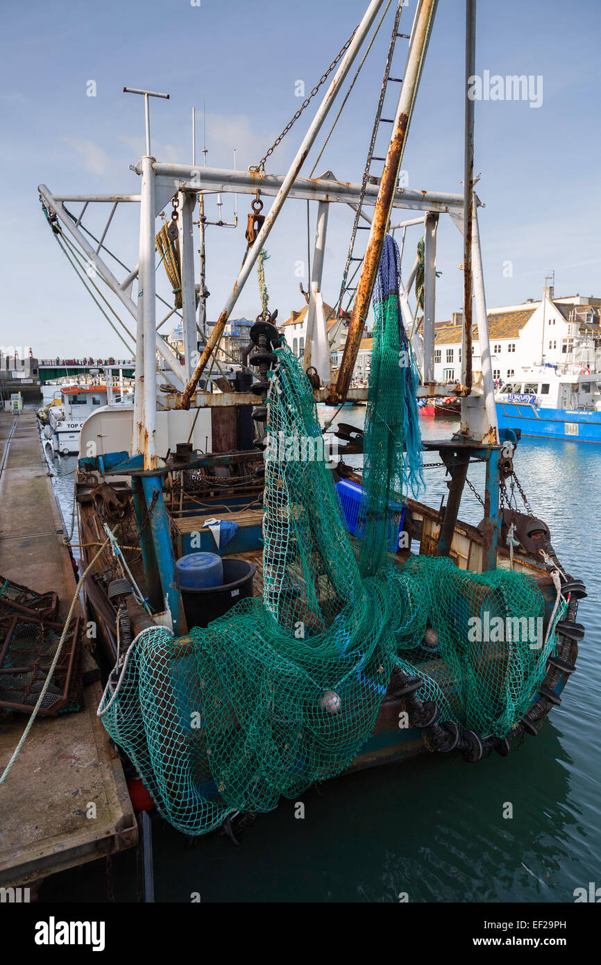 A commercial fishing trawler is seen from the rear showing its nets and preparing for its next fishing trip. Stock Photo