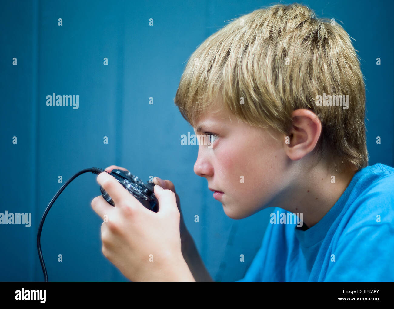 Young boy, 10-11-12-13, playing video game using controller with concentration Stock Photo