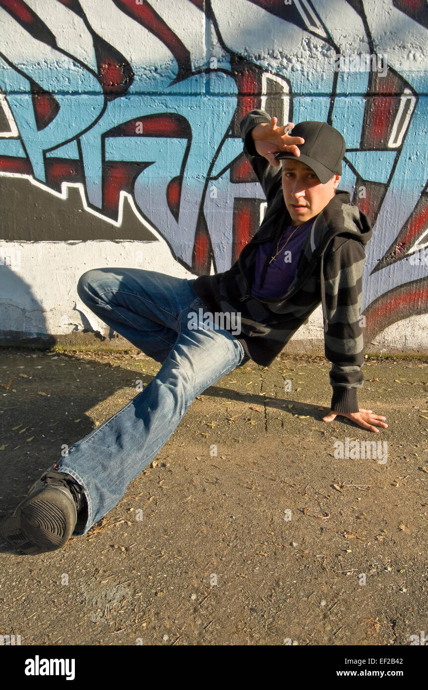 Teenage boy break dancing in front of wall of graffiti Stock Photo - Alamy