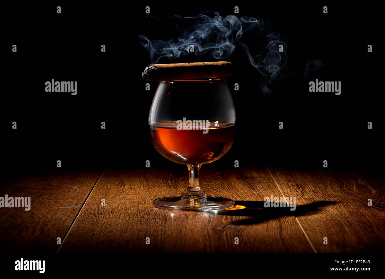 Havana cigar on a wineglass of whiskey Stock Photo