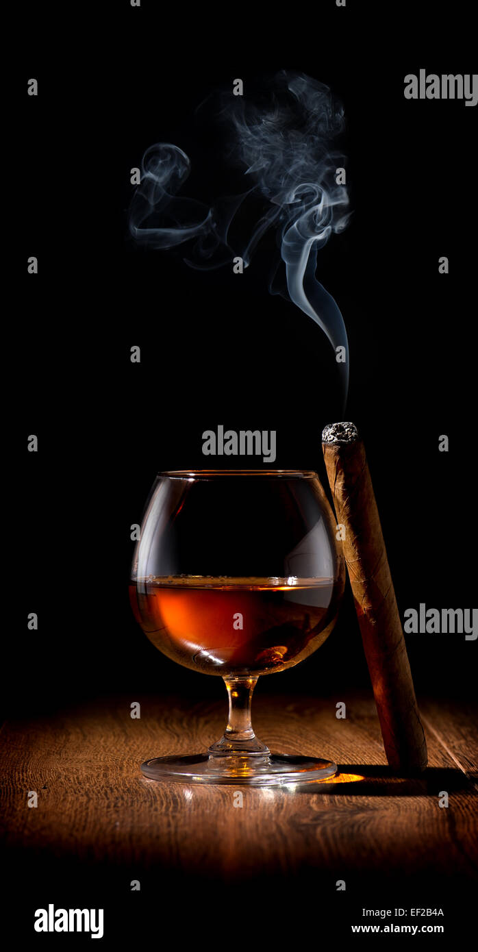 Wineglass of scotch and cigar on wooden table Stock Photo