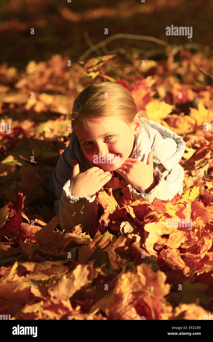 little girl laying in yellow leaves in the autumn park Stock Photo - Alamy