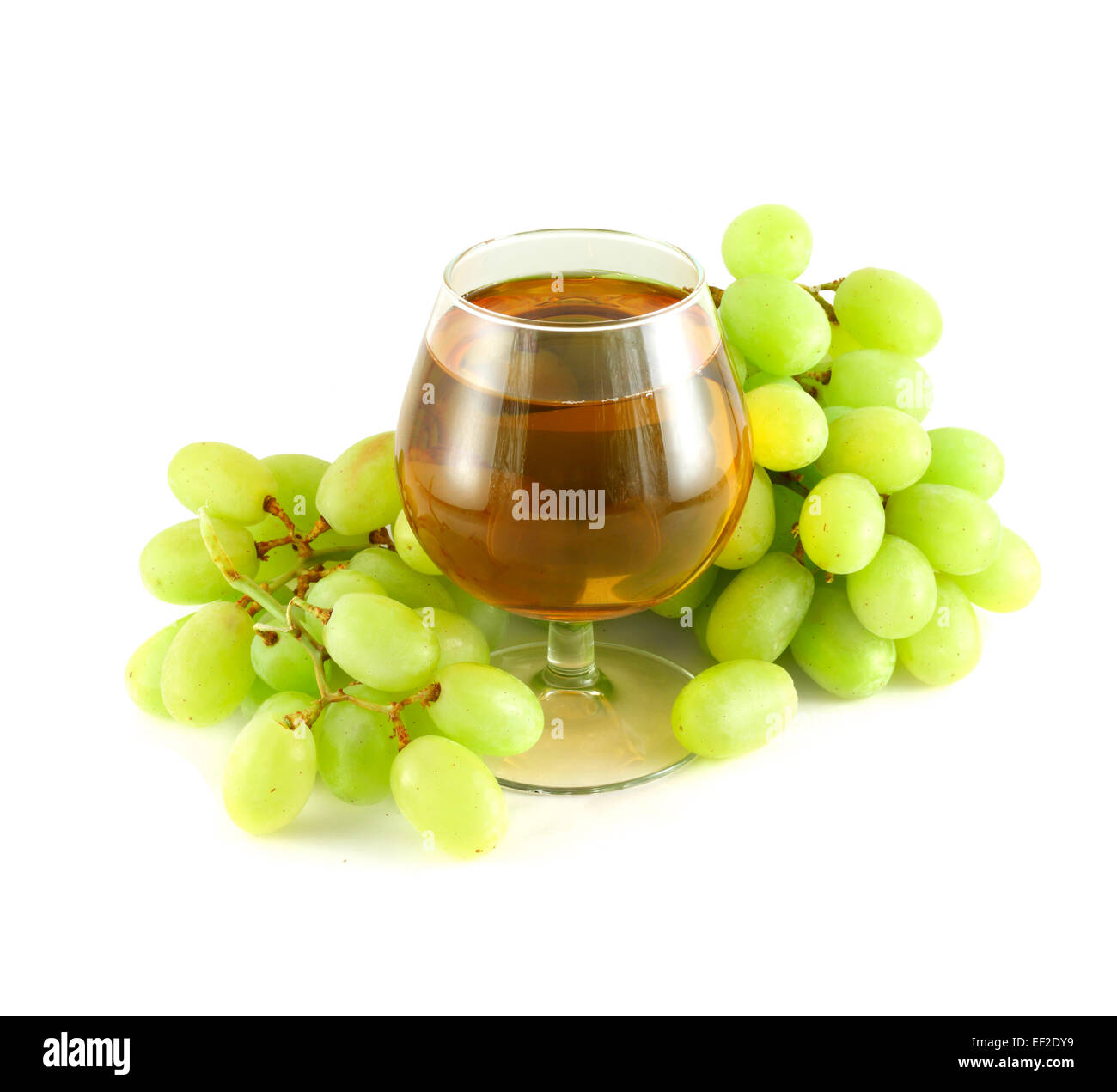 Grape juice in wine glass surrounded with grapes isolated on white