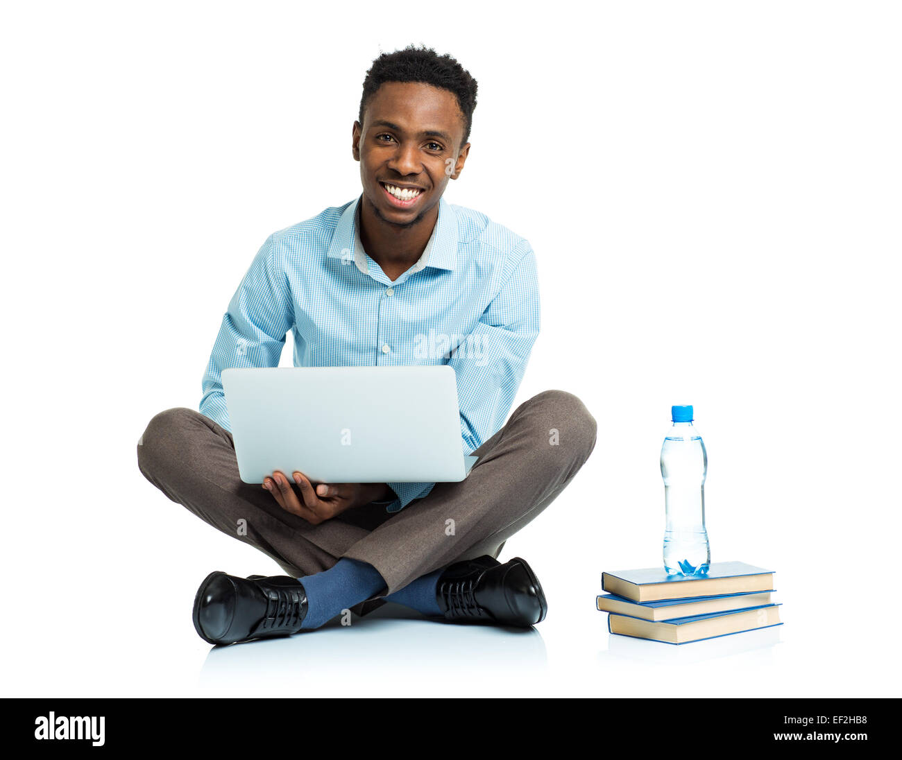 Happy african american college student sitting with laptop on white background Stock Photo