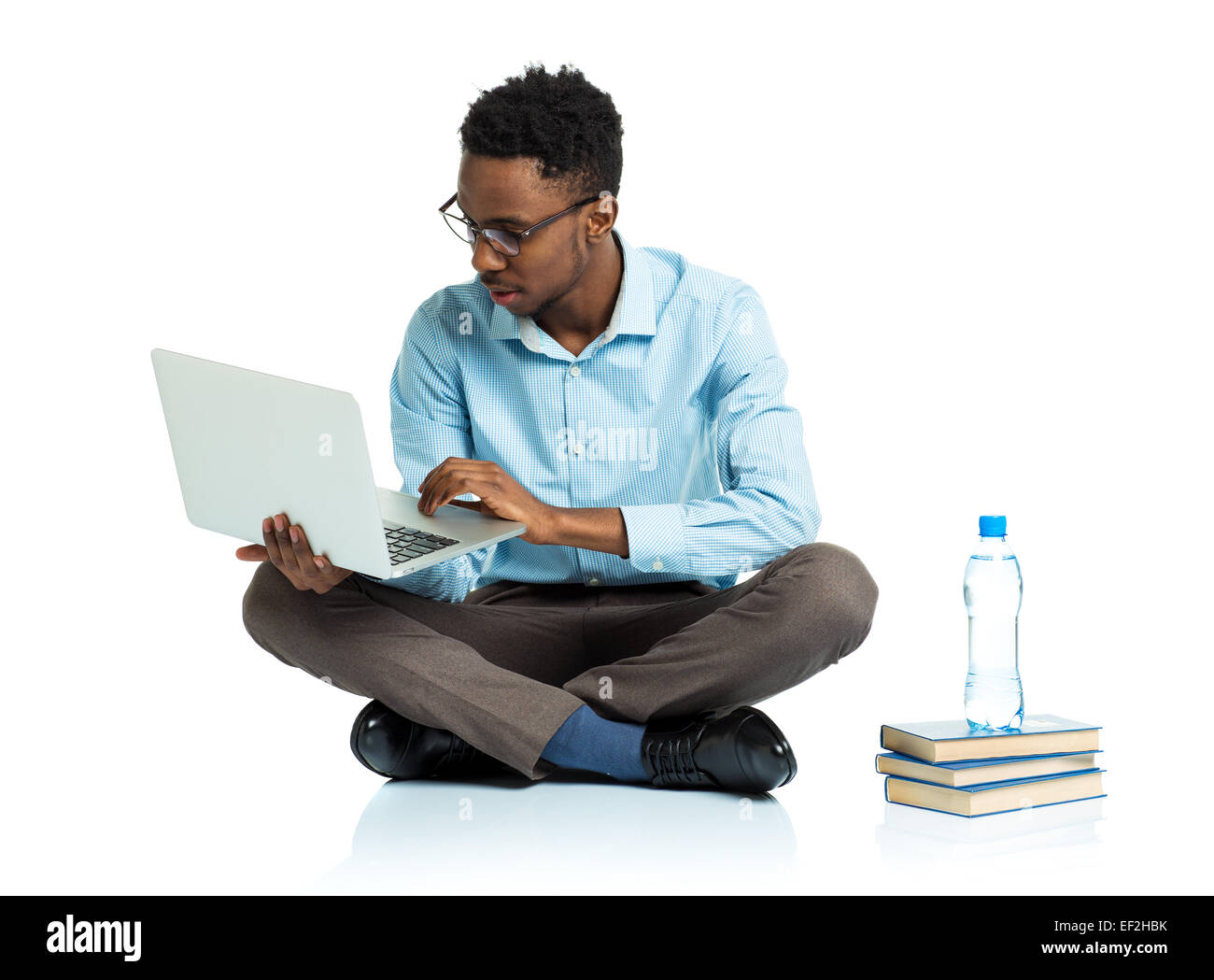 Happy african american college student sitting with laptop on white ...