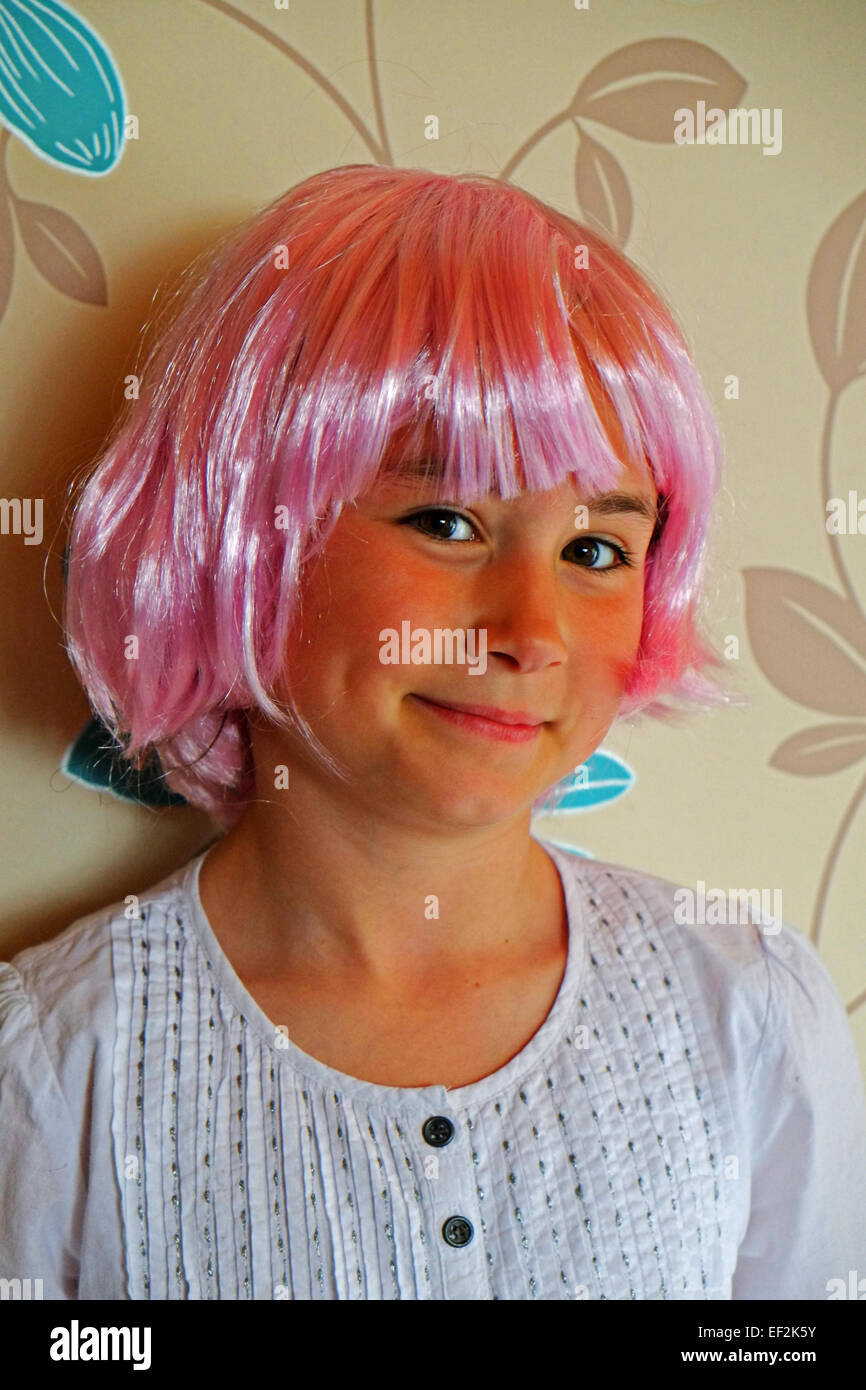 A smiling young girl wearing a vivid pink party wig Cork Ireland Stock Photo