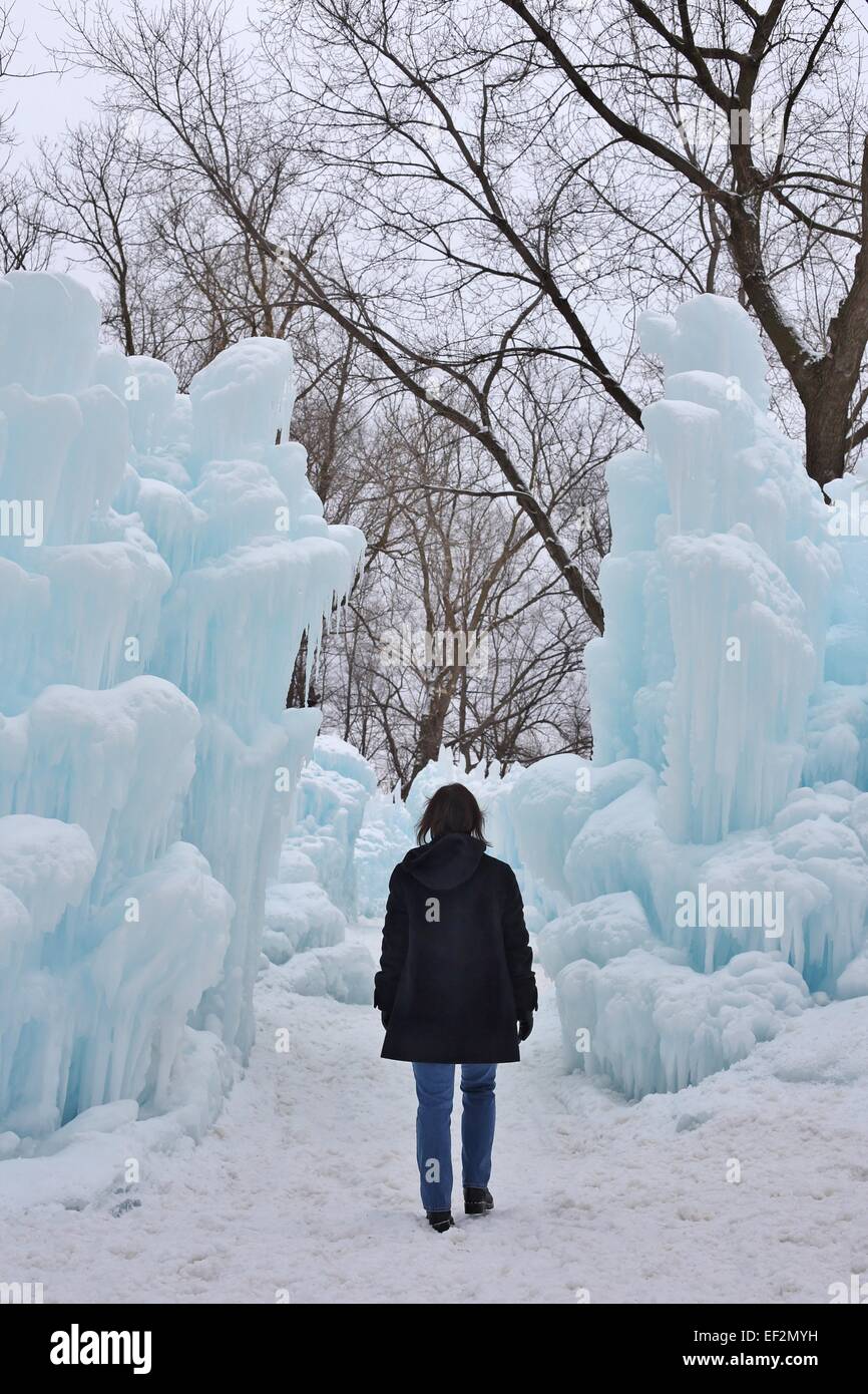 A woman walking near an ice castle in Eden Prairie, Minnesota. Stock Photo