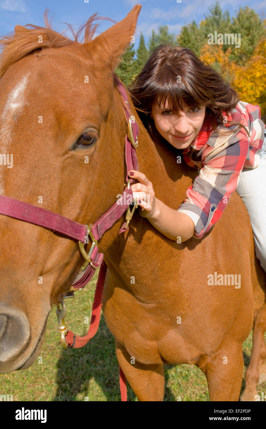 Woman lying down on a horse Stock Photo
