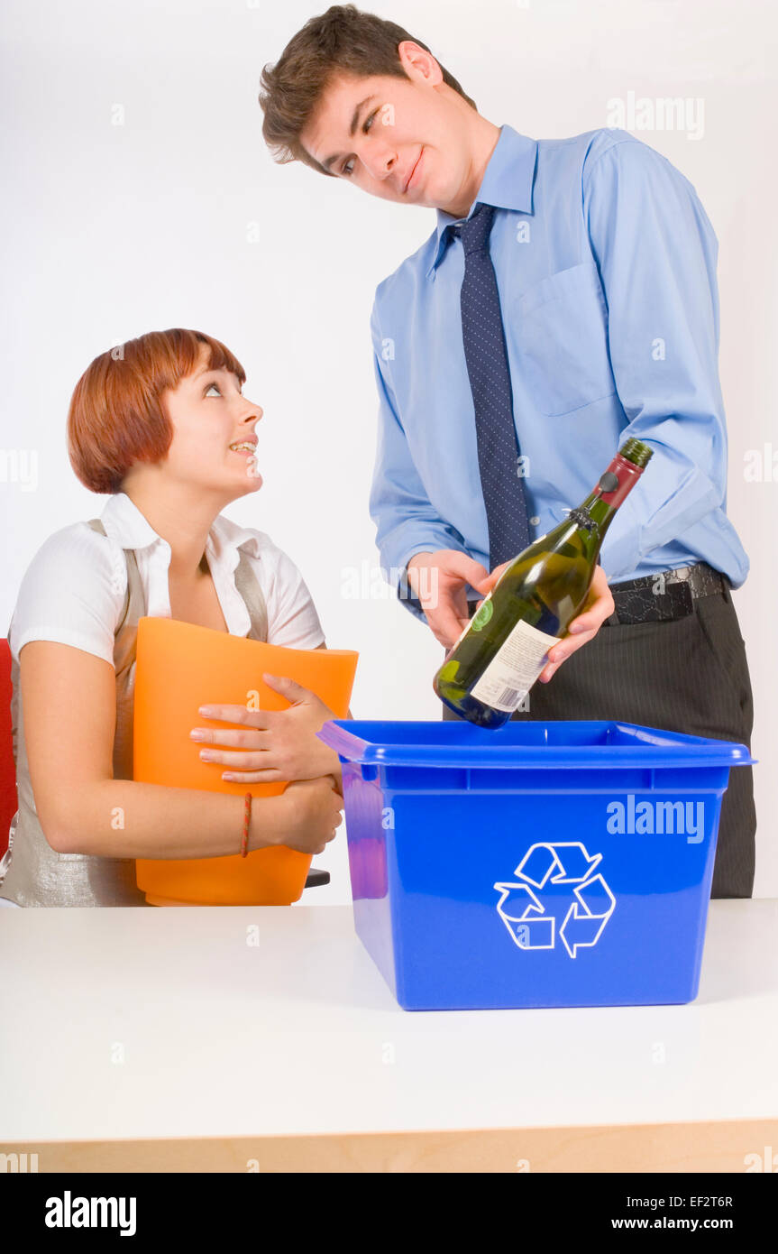Man putting wine bottle in office recycle bin Stock Photo