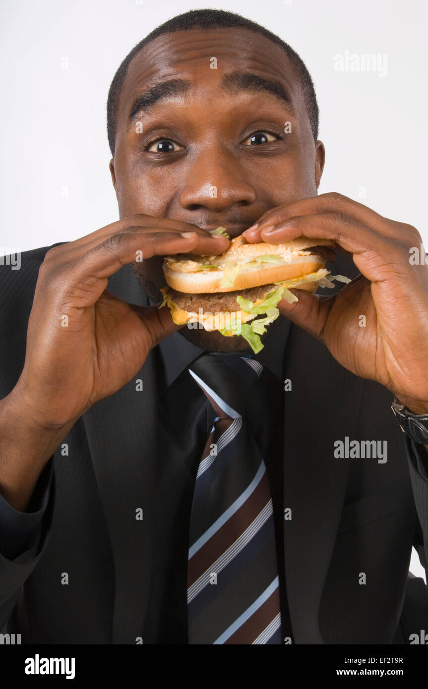 Businessman eating a hamburger Stock Photo