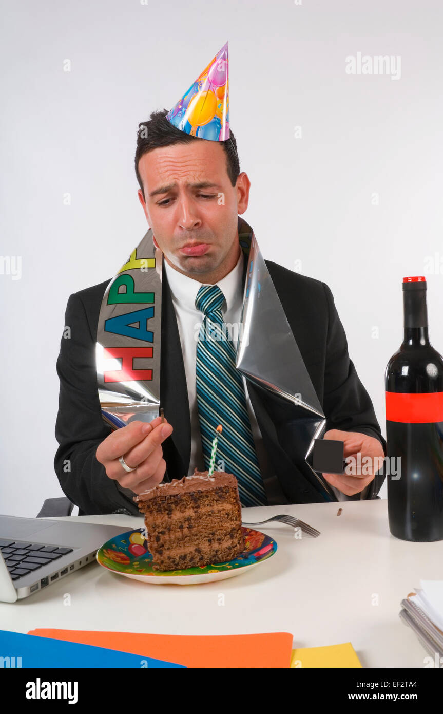 Disappointed businessman celebrating his birthday at work Stock Photo