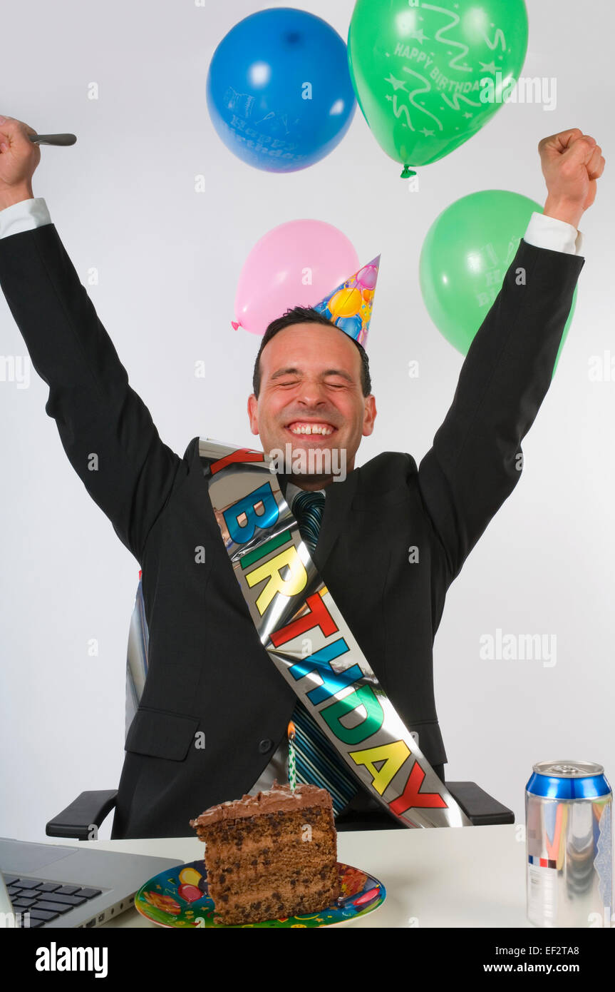 Excited businessman eating birthday cake at his desk Stock Photo Alamy
