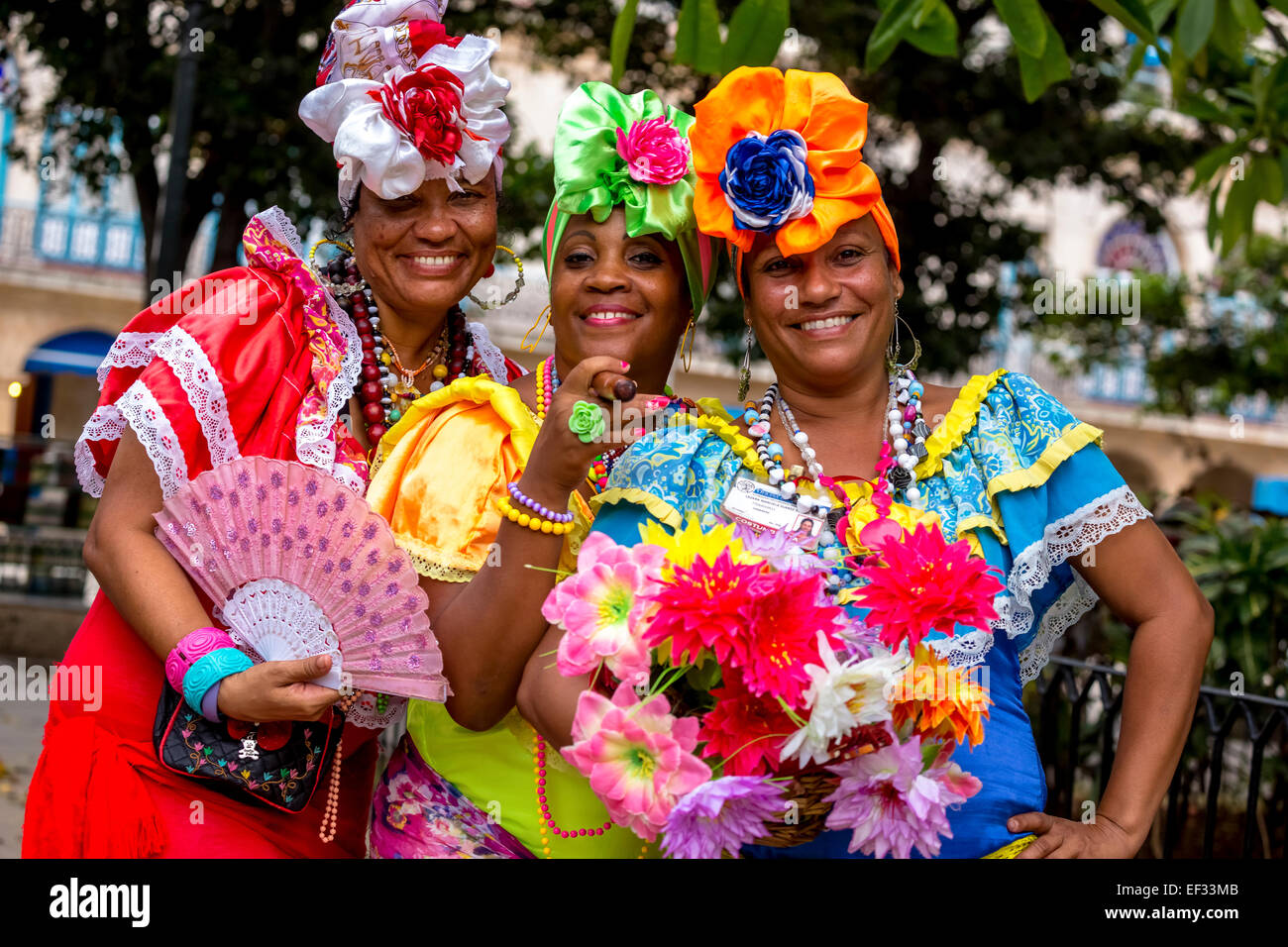 Three Cuban women in colorful Spanish-inspired costumes, Havana, Cuba Stock Photo