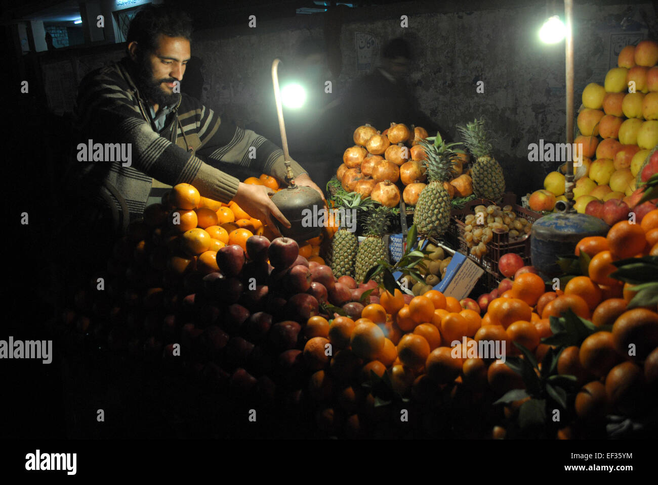 Peshawar 25th Jan 2015 A Pakistani Fruit Vendor Waits For Customers During A Power Cut In 