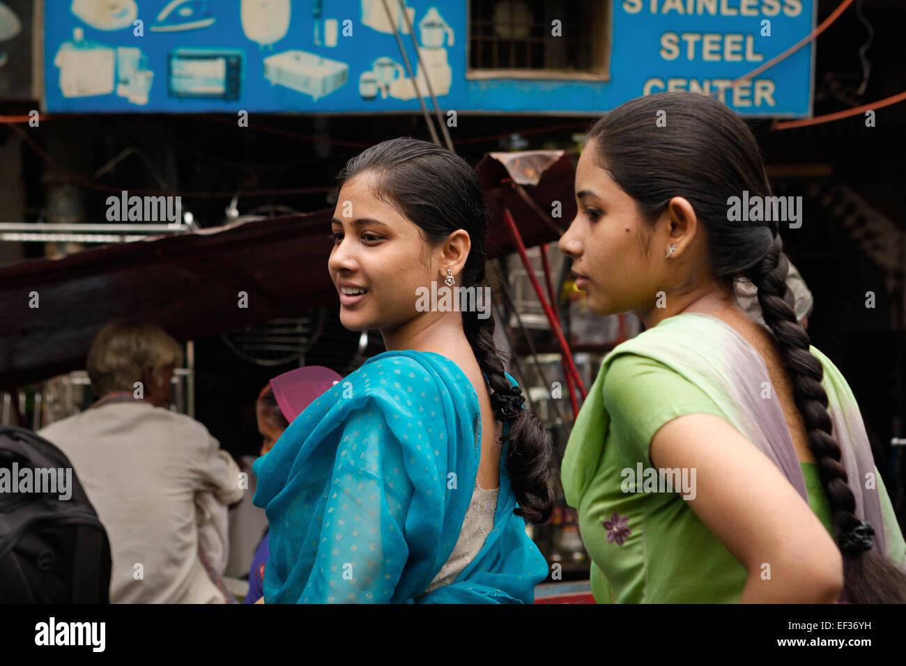 Girls having conversation during a traffic congestion as they are riding bicycle in Varanasi, Uttar Pradesh, India Stock Photo