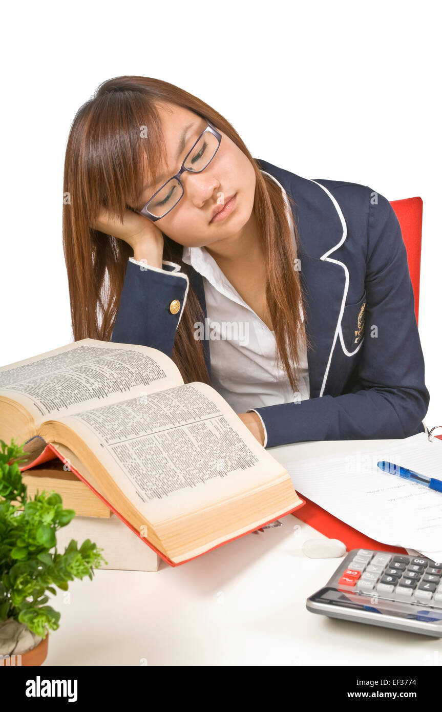 Tired teenage student sitting at her desk Stock Photo