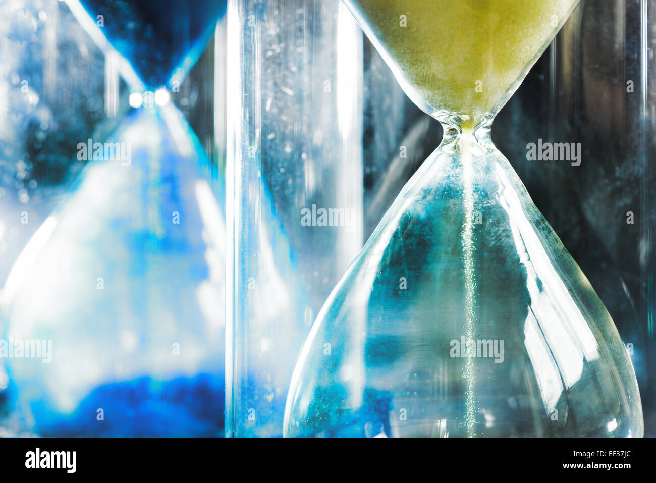 timer hourglass streaming grains of sand flowing through depicting things are running out Stock Photo