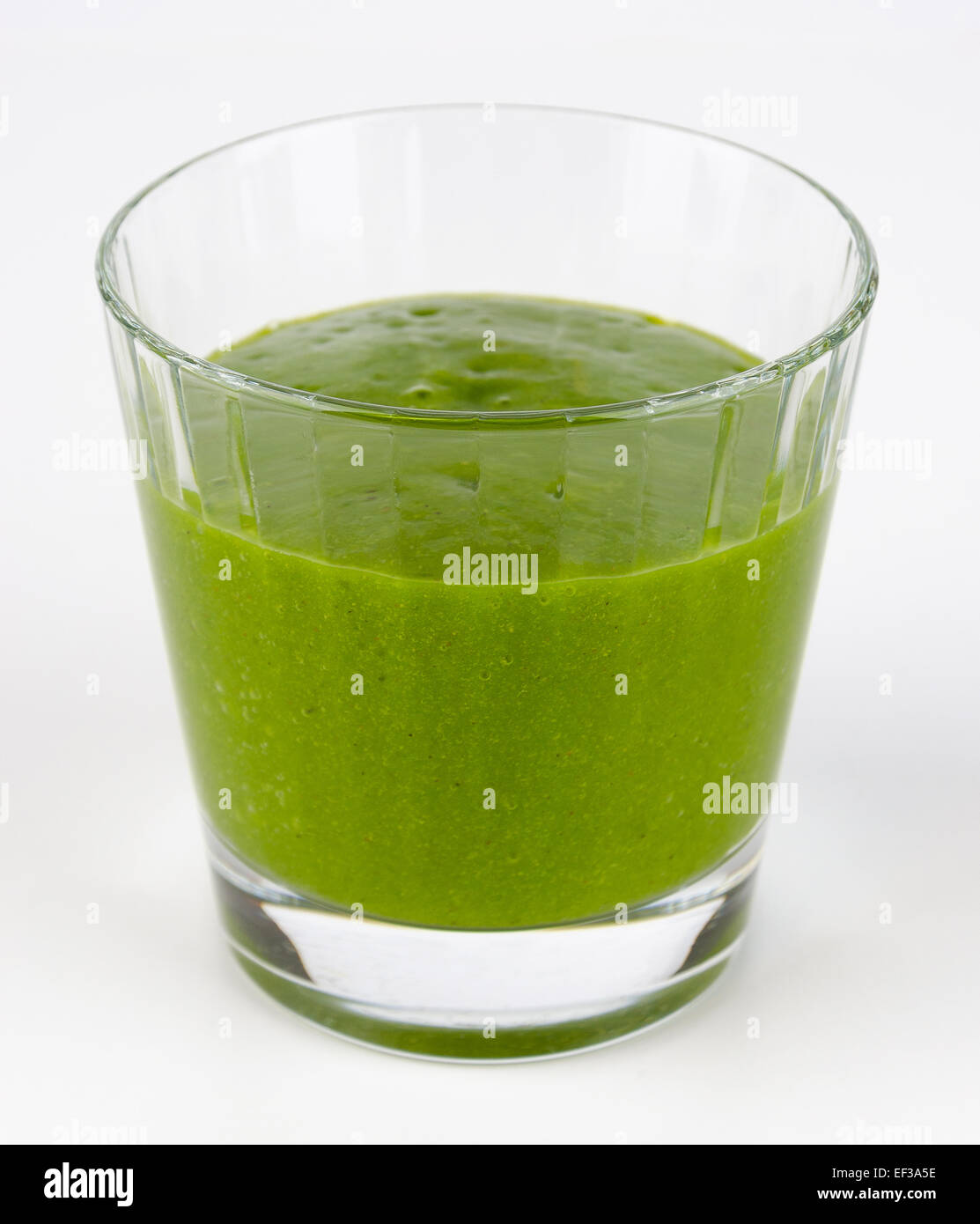 Green smoothie made of organic spinach, kale and fruits in a glass. A raw, healthy, fresh and vegan beverage. Stock Photo