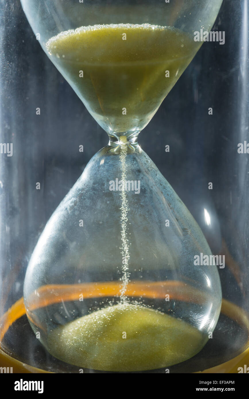 timer hourglass streaming grains of sand flowing through depicting
