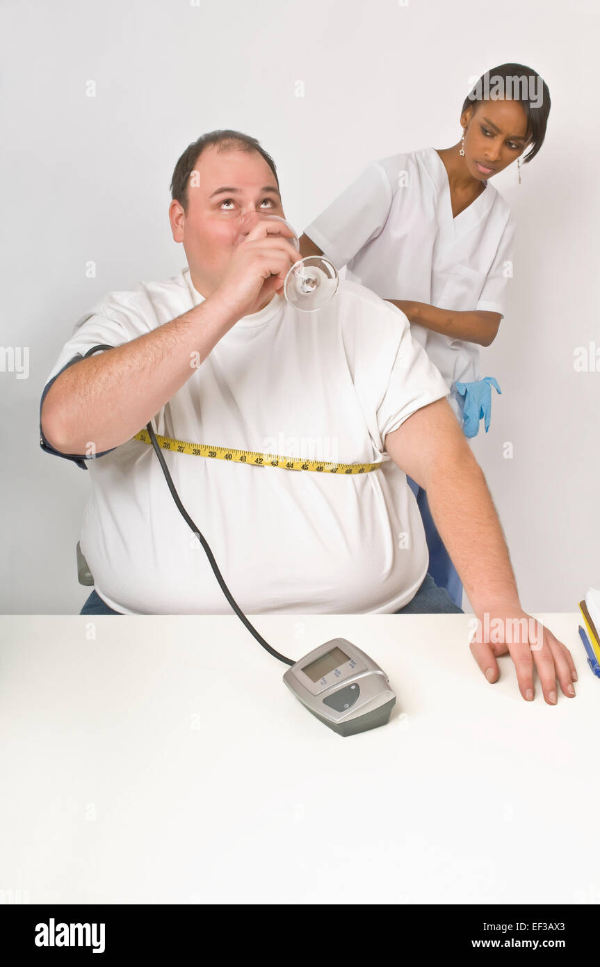 Nurse measuring overweight man's midriff Stock Photo