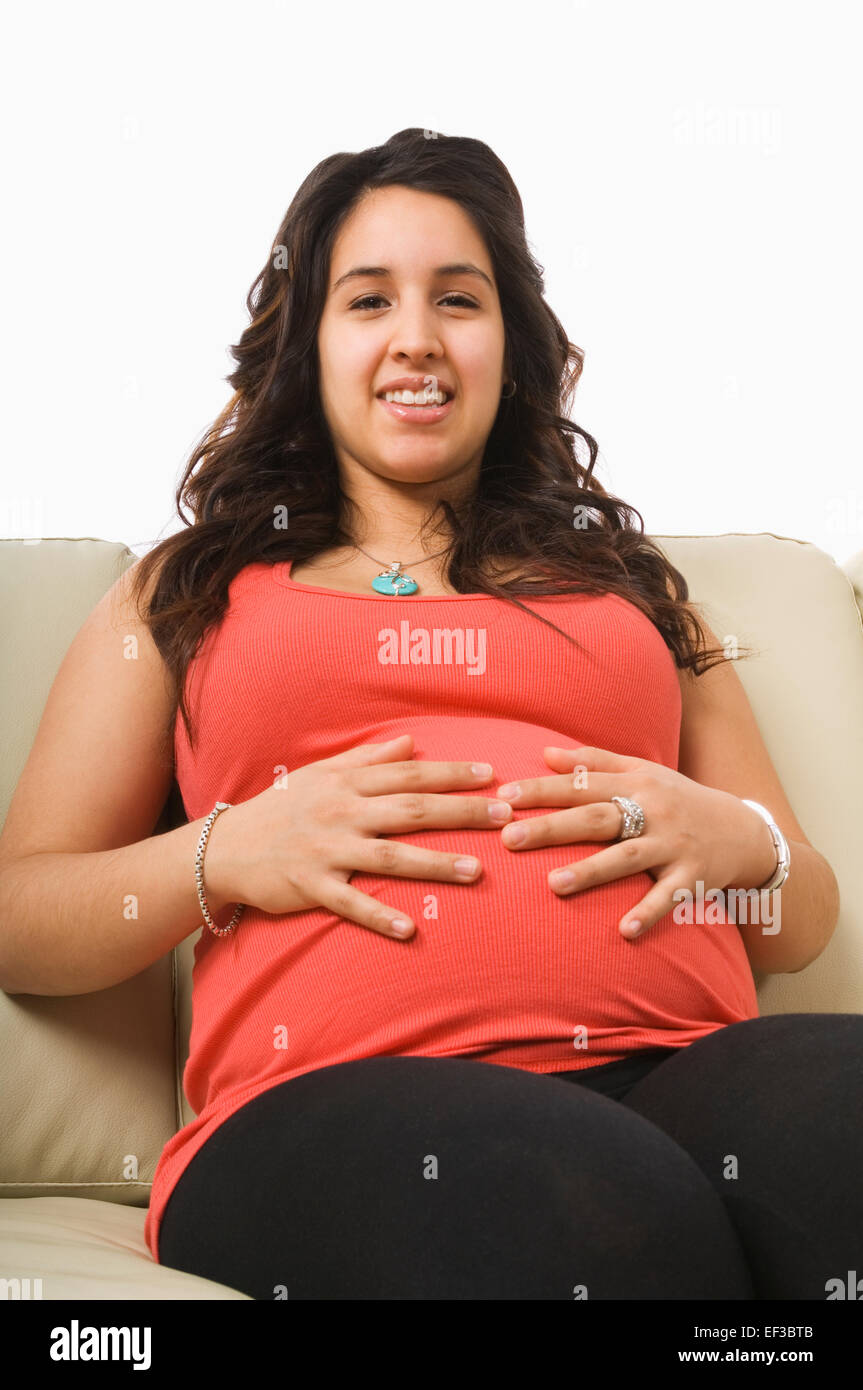 Pregnant woman sitting on couch Stock Photo Alamy