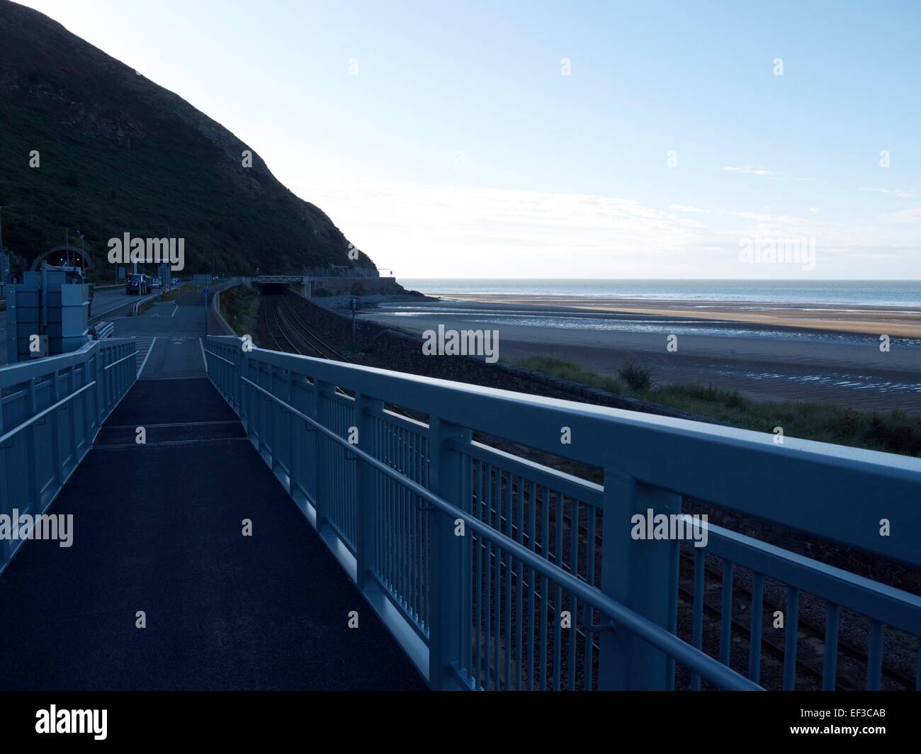 Cycle path with beaches to the right and the road heading for a tunnel on the left Stock Photo