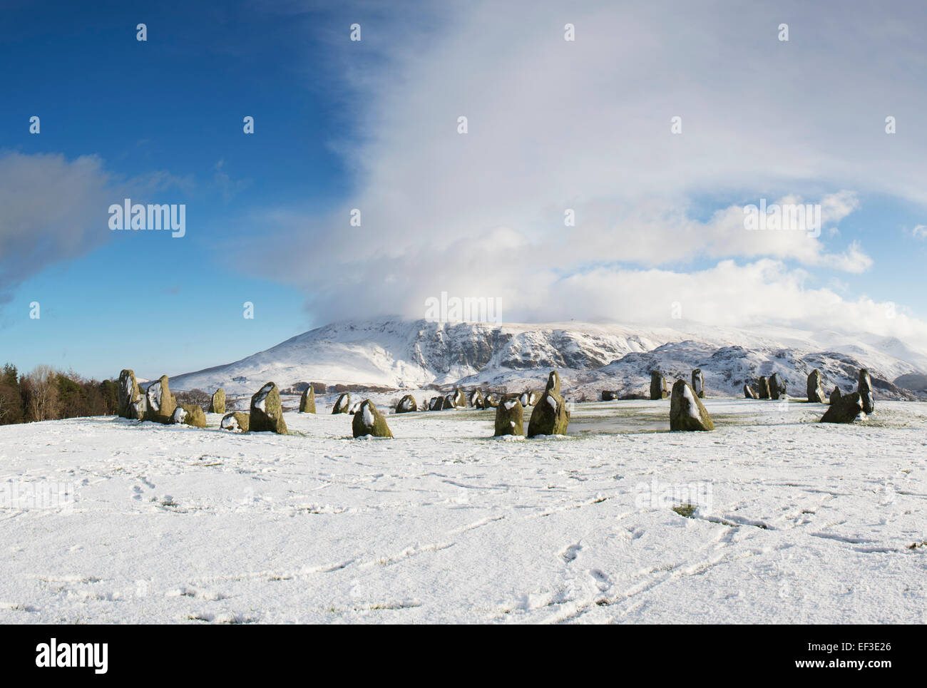 Castlerigg stone circle in front of Helvellyn mountain range in the winter snow. Lake District, Cumbria, England. Stock Photo