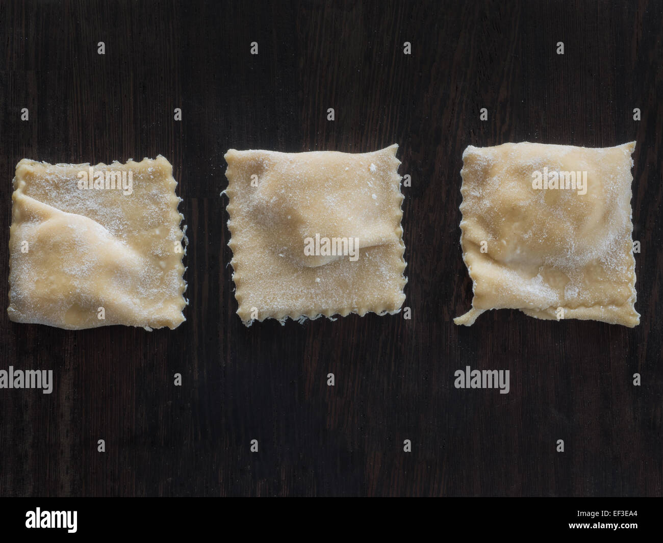 Fresh made ravioli with flour on a wooden board Stock Photo