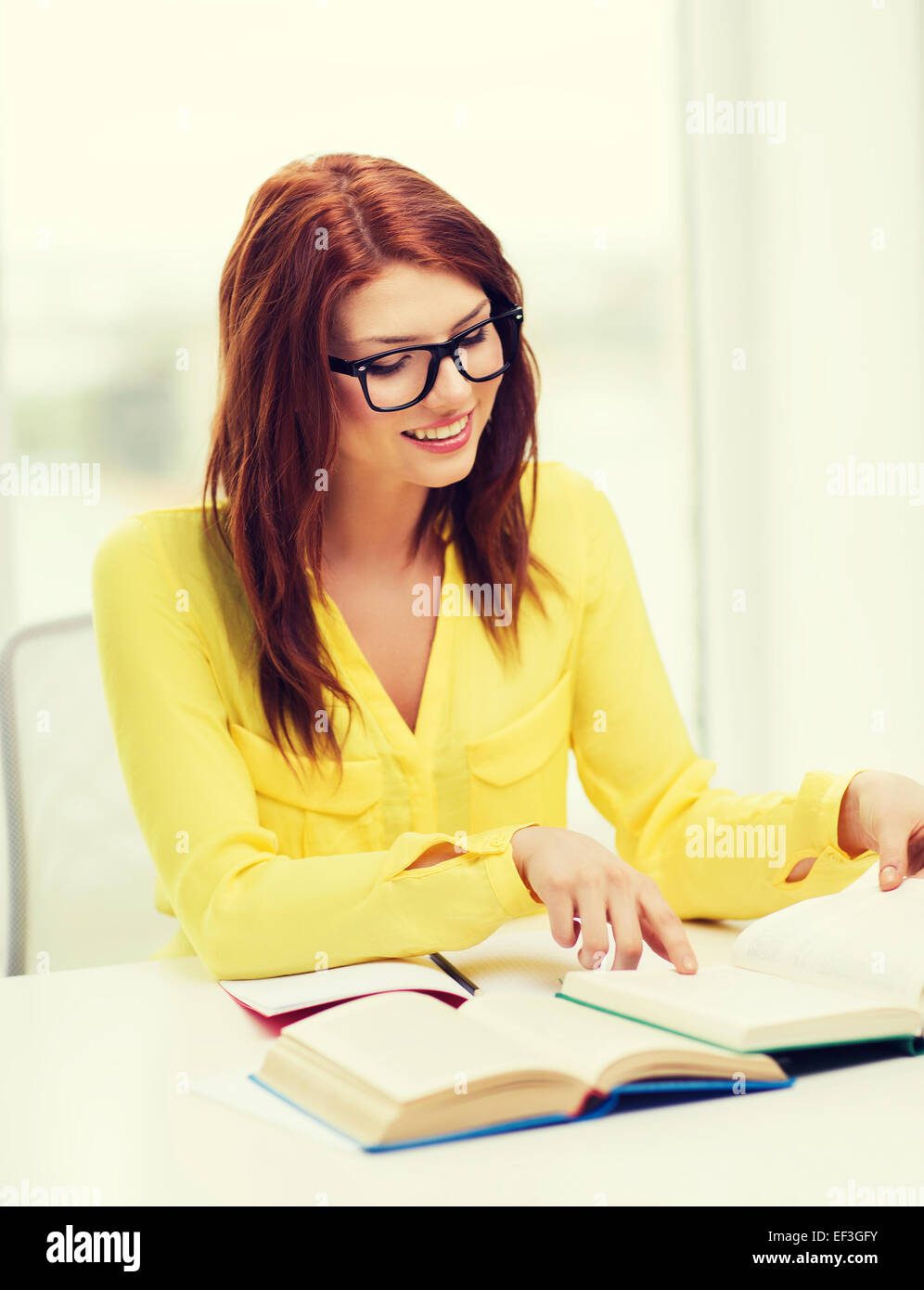 smiling student girl reading books in college Stock Photo - Alamy