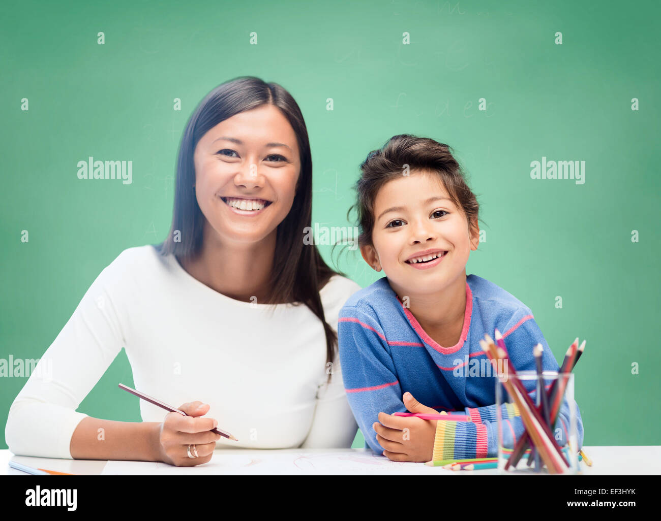 happy teacher and little schoolgirl drawing Stock Photo - Alamy