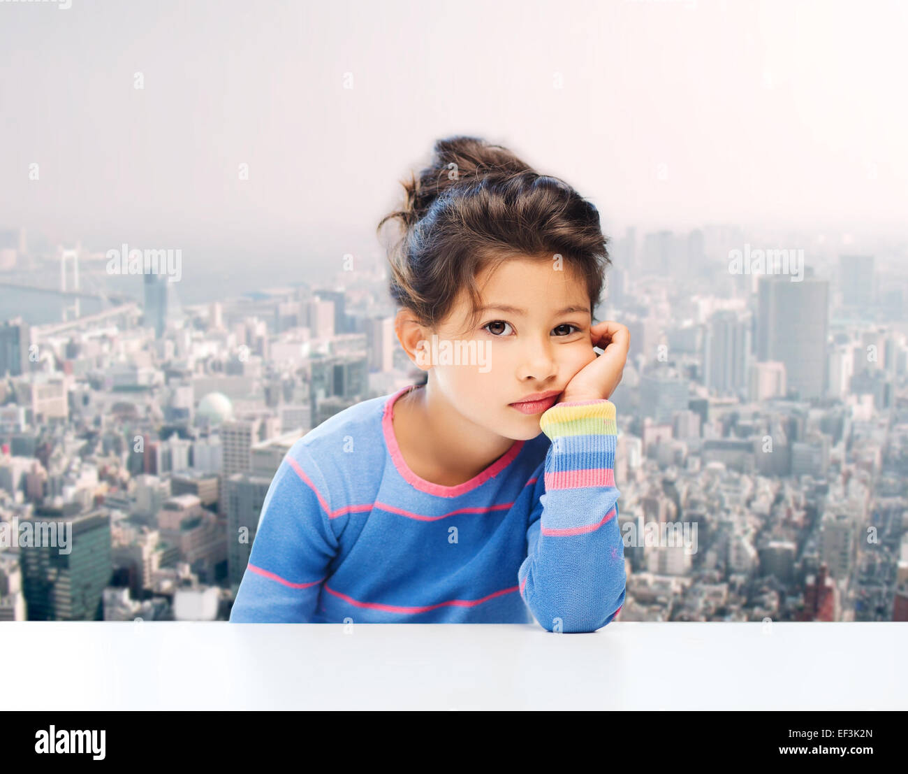 sad little girl over city background Stock Photo