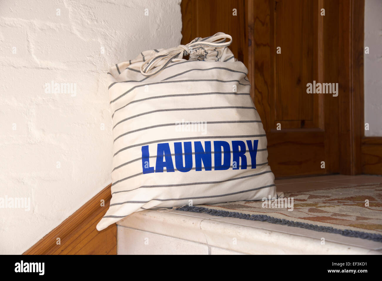 Full laundry bag outside a door waiting collection of dirty or clean