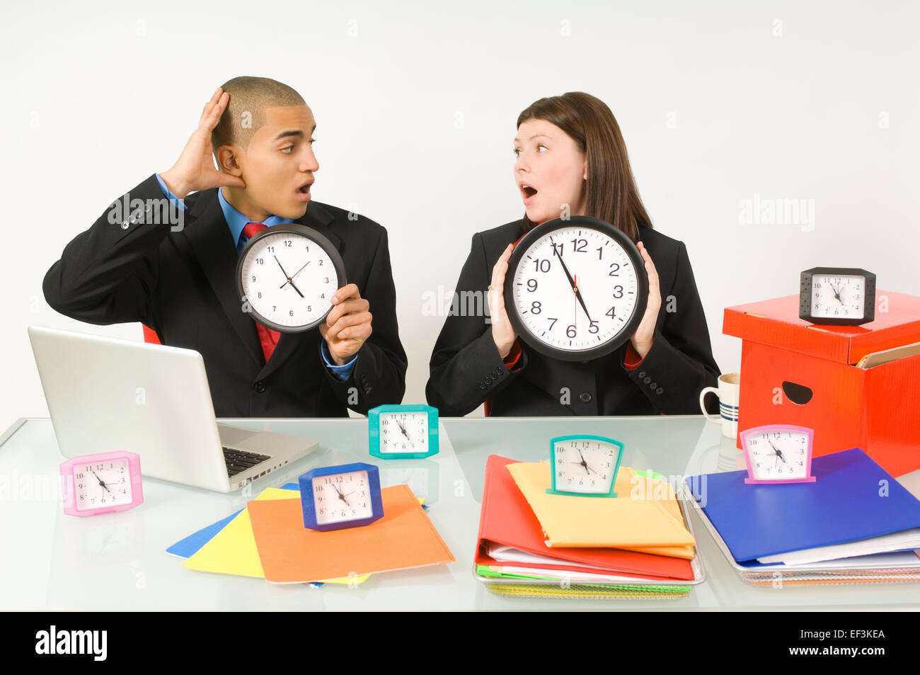 Colleagues holding clocks Stock Photo